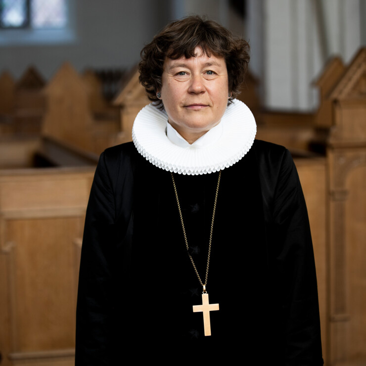 Biskop Marianne Christiansen i præstekjole og kæde med kors om halsen